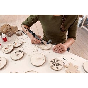 Mujer grabando posavasos de madera con un Stylo