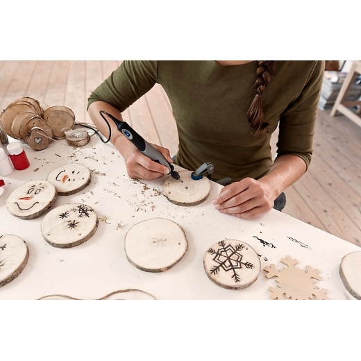 Mujer grabando posavasos de madera con un Stylo