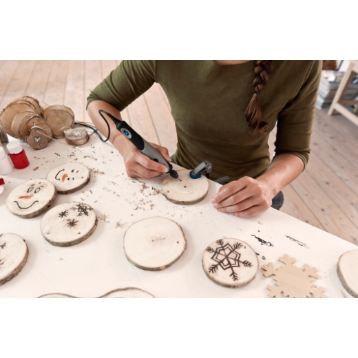 Mujer grabando posavasos de madera con un Stylo