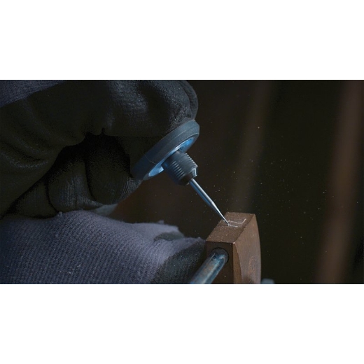 Una persona grabando en una pieza de madera, utilizando una multiherramienta Dremel acoplada a la broca de grabado Dremel 105
