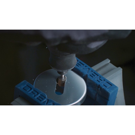 Una multiherramienta Dremel acoplada a la broca de trinchar Dremel 115 que se está utilizando