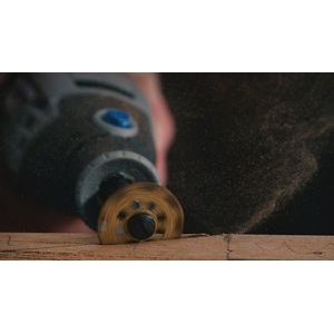 Una multiherramienta Dremel acoplada a la rueda de corte/modelado Dremel 542 que se utiliza para cortar madera