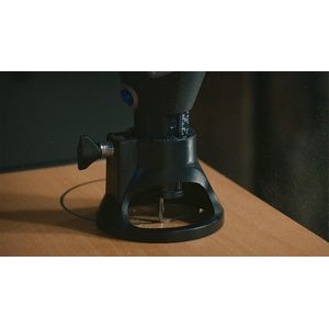 Una multiherramienta Dremel acoplada a las brocas de corte en espiral Dremel 561 multiusos con el accesorio de corte multiusos Dremel que se utiliza para cortar una pieza de madera