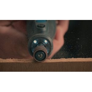 Una multiherramienta Dremel acoplada a la banda de lija Dremel 408 que se utiliza para lijar madera