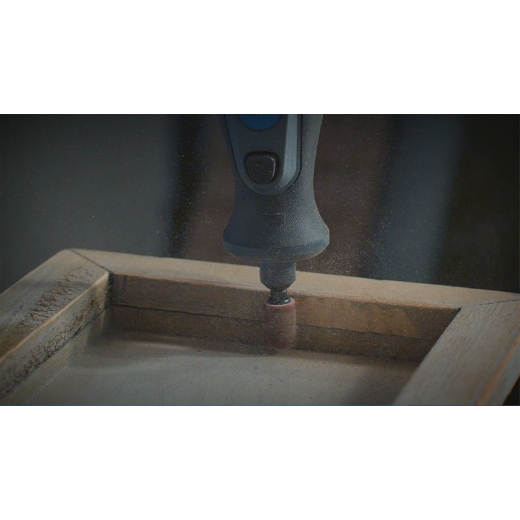 Una multiherramienta Dremel acoplada a la banda de lija Dremel 438 que se utiliza para lijar madera