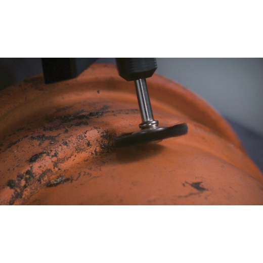 Dremel 403 Borstenbürste zum Reinigen einer orangefarbenen Oberfläche