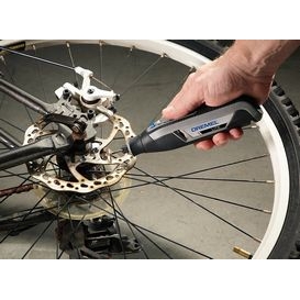 Una persona que usa Dremel 7760 lite para limpiar el óxido de una rueda de bicicleta