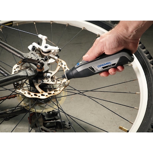 Una persona que usa Dremel 7760 lite para limpiar el óxido de una rueda de bicicleta